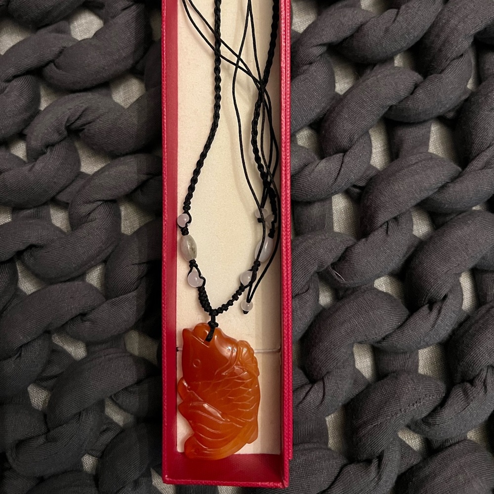 Jade wish pendant necklace on silk cord.